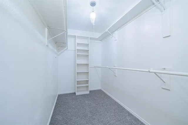 a bedroom with a bed chandelier and a window