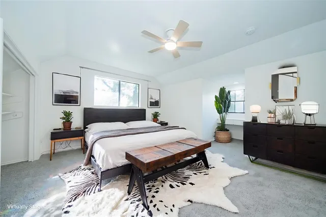 a spacious bedroom with a bed and wooden cabinets