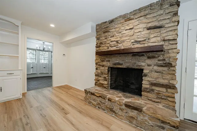 a view of empty room with wooden floor and fireplace