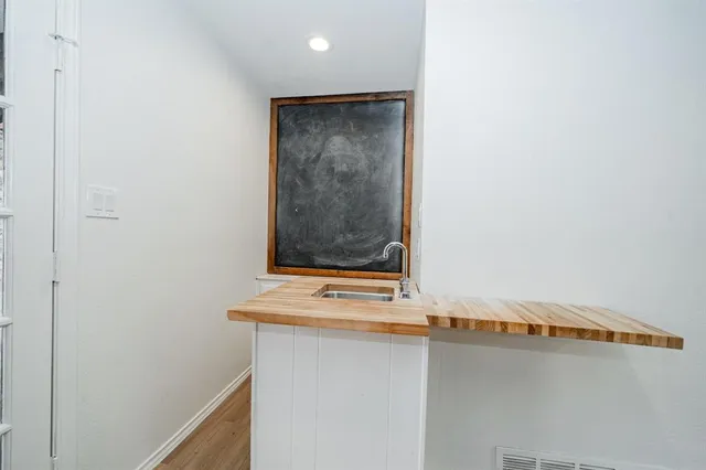 a view of a kitchen with a sink dishwasher a refrigerator and cabinets