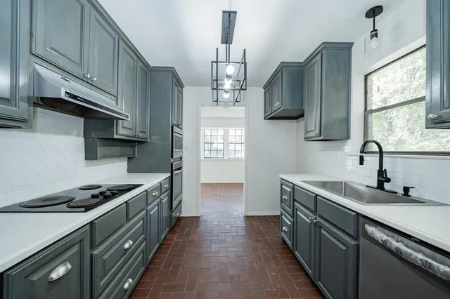 a kitchen with granite countertop cabinets stainless steel appliances and wooden floor