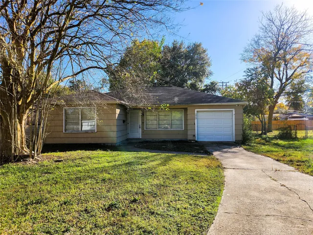a view of a house with a large tree and a yard