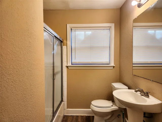 a bathroom with a sink a toilet and a mirror