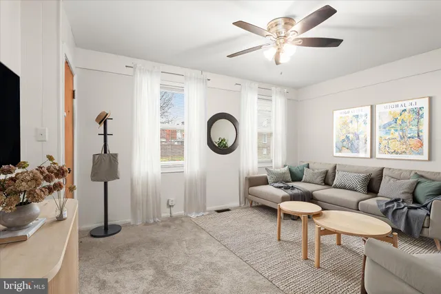 a living room with furniture a chandelier fan and a window
