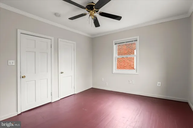an empty room with a window and a ceiling fan