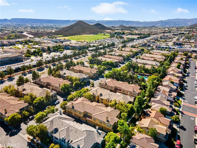 an aerial view of residential houses with outdoor space and trees