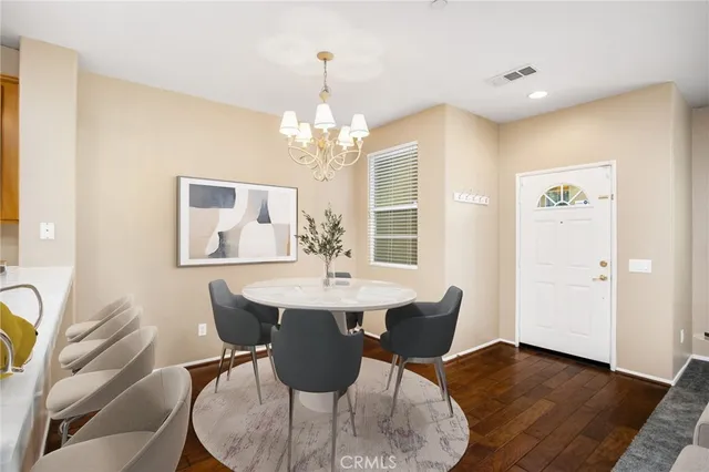 a dining room with wooden floor a glass table and chairs