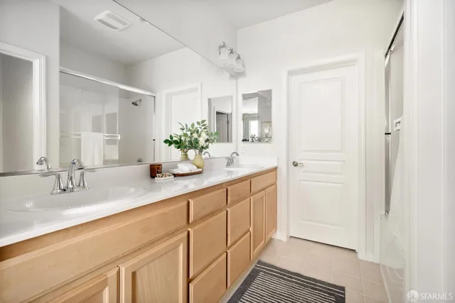a bathroom with double vanity sink and a mirror