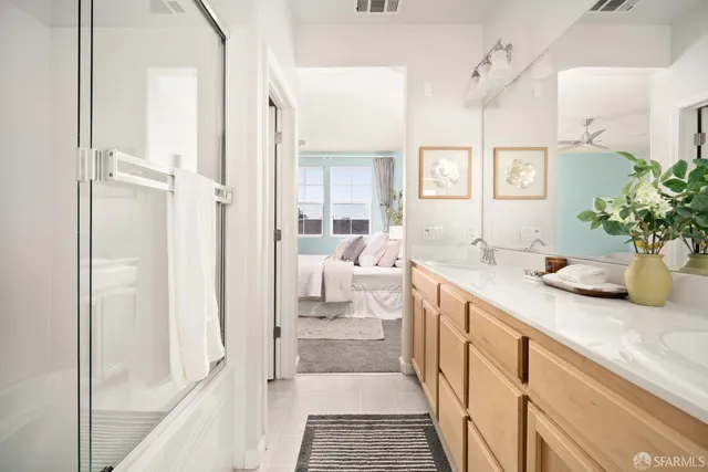 a bathroom with a double vanity sink a mirror and a shower