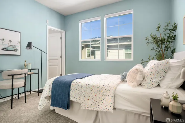 a bedroom with a large bed and a potted plant