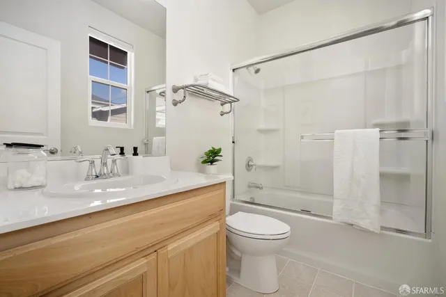 a bathroom with a granite countertop sink a toilet and shower
