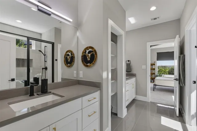 a spacious bathroom with a granite countertop sink and a large mirror