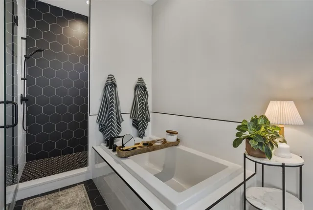 a bathroom with a tub and a potted plant