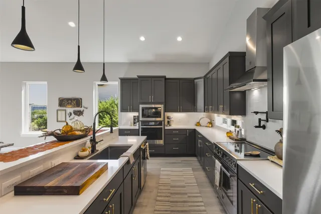 a kitchen with stainless steel appliances a sink stove and refrigerator