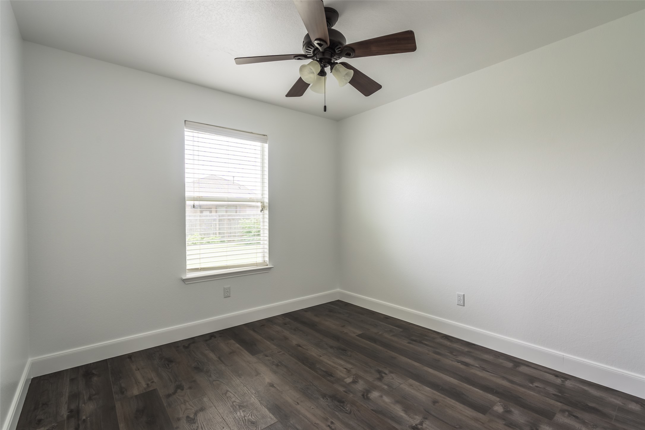 1013 Ranchero Road Leander, TX 78641 - Photo 18 of 30 Rich wood-look flooring and a classic window define this versatile bedroom space.