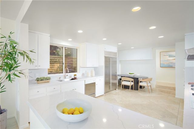 a kitchen with stainless steel appliances granite countertop a refrigerator and a sink