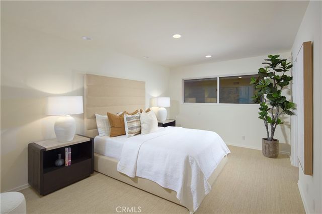 a bedroom with bed and a potted plant