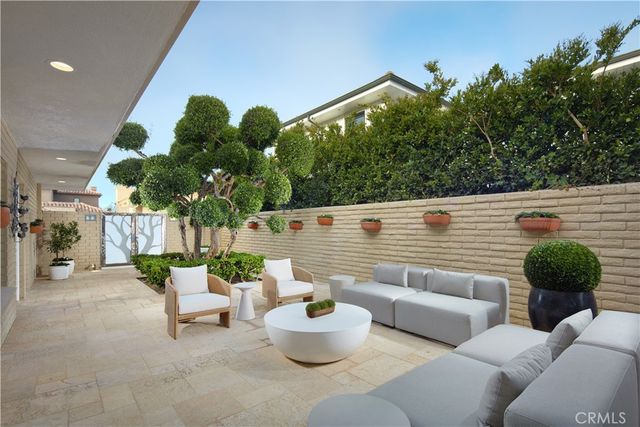 a view of a patio with couches table and chairs and potted plants