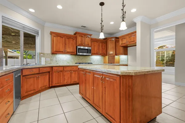 a kitchen with stainless steel appliances granite countertop a stove a sink and a microwave