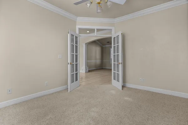 an empty room with a window and a fan