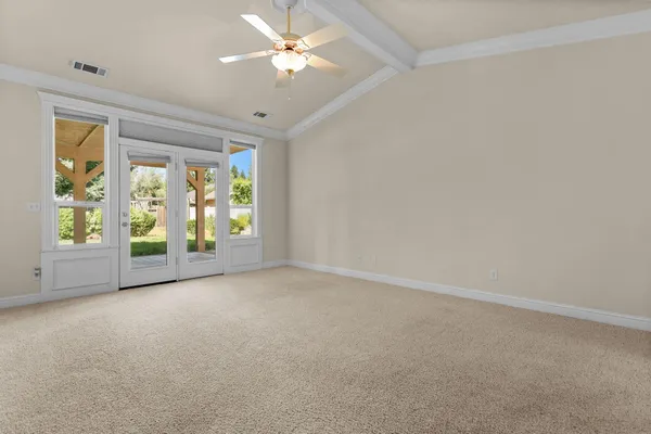 an empty room with a ceiling fan and a window