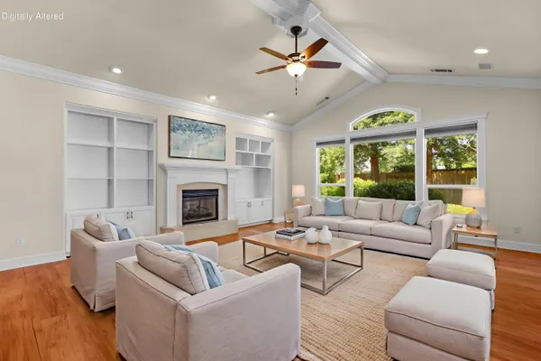 an empty room with windows fireplace and a ceiling fan