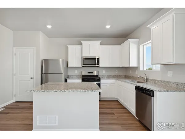 a kitchen with stainless steel appliances granite countertop a refrigerator sink stove and microwave