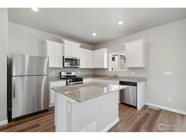 a kitchen with granite countertop stainless steel appliances a refrigerator a stove a sink a microwave and cabinets