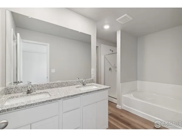 a bathroom with a granite countertop sink mirror and a bath tub