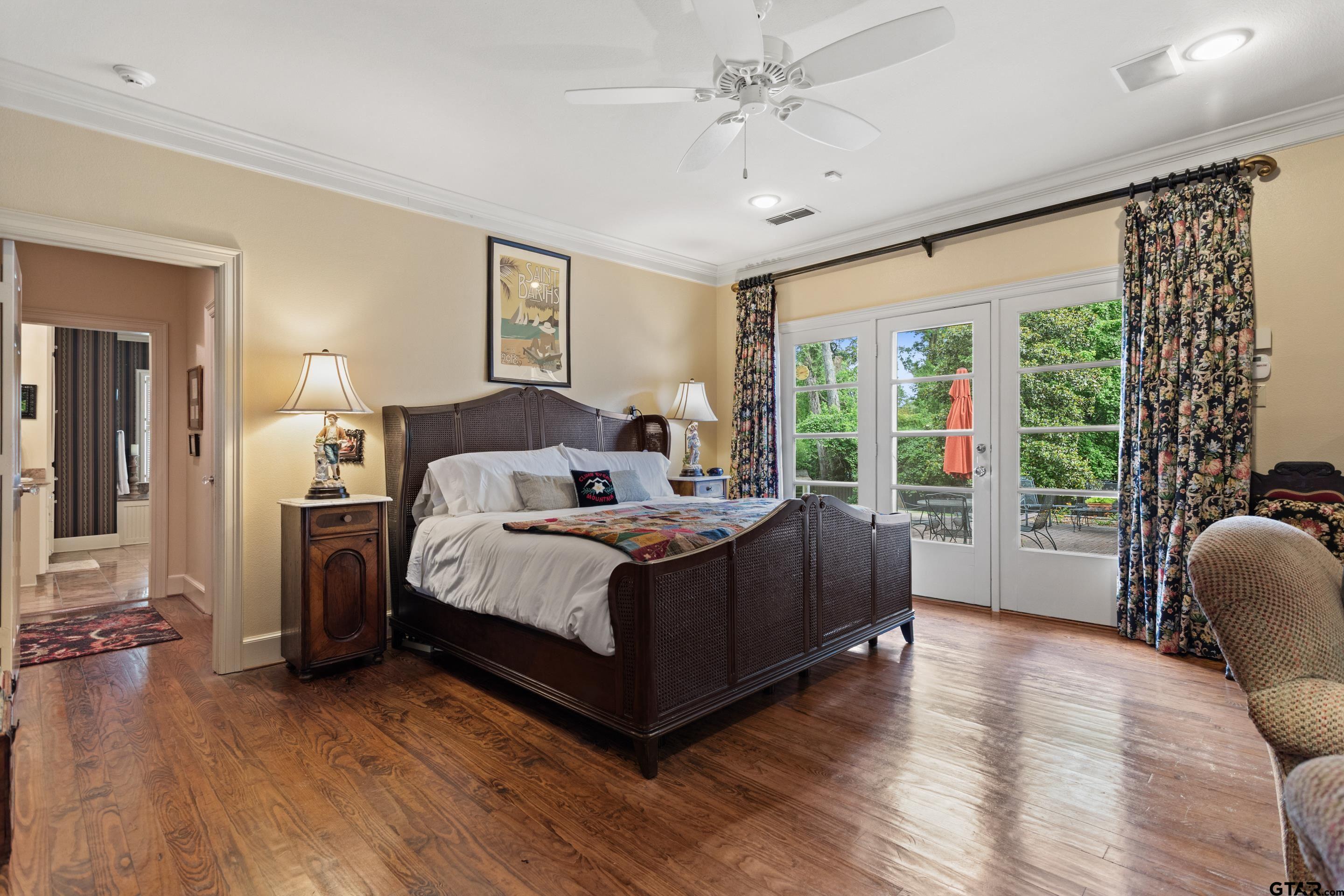 2631 Old Bullard Road Tyler, TX 75701 - Photo 18 of 43 a bedroom with a bed wooden floor and large window