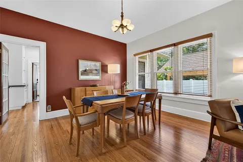 a view of a a dining room with furniture window and wooden floor