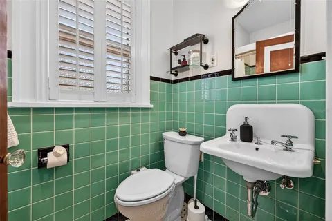 a bathroom with a sink mirror and toilet