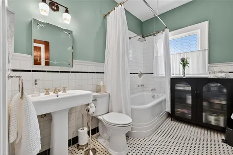 a bathroom with a sink toilet a mirror and shower