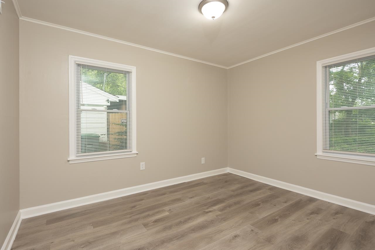 4574 Boyce Road Memphis, TN 38117 - Photo 20 of 28 an empty room with wooden floor and windows