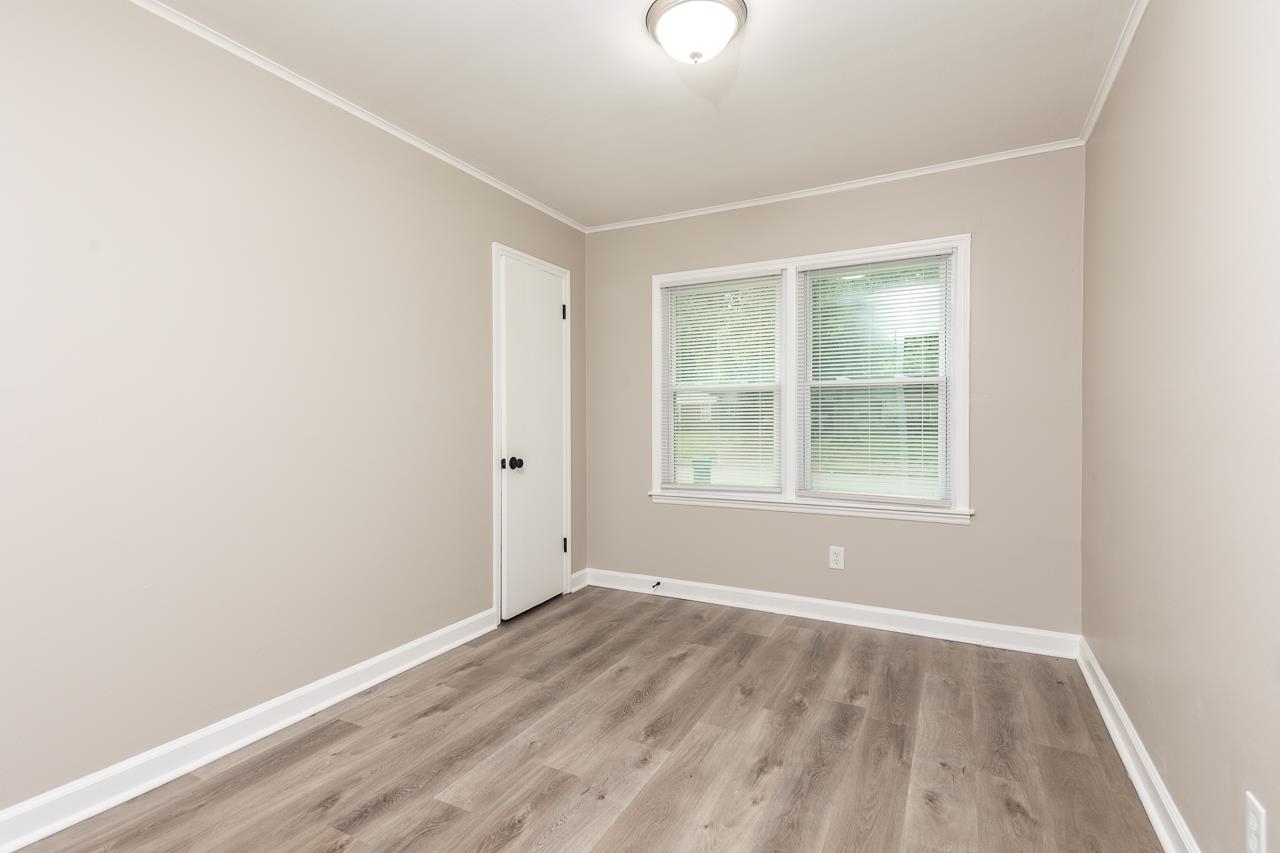 4574 Boyce Road Memphis, TN 38117 - Photo 21 of 28 an empty room with wooden floor and windows