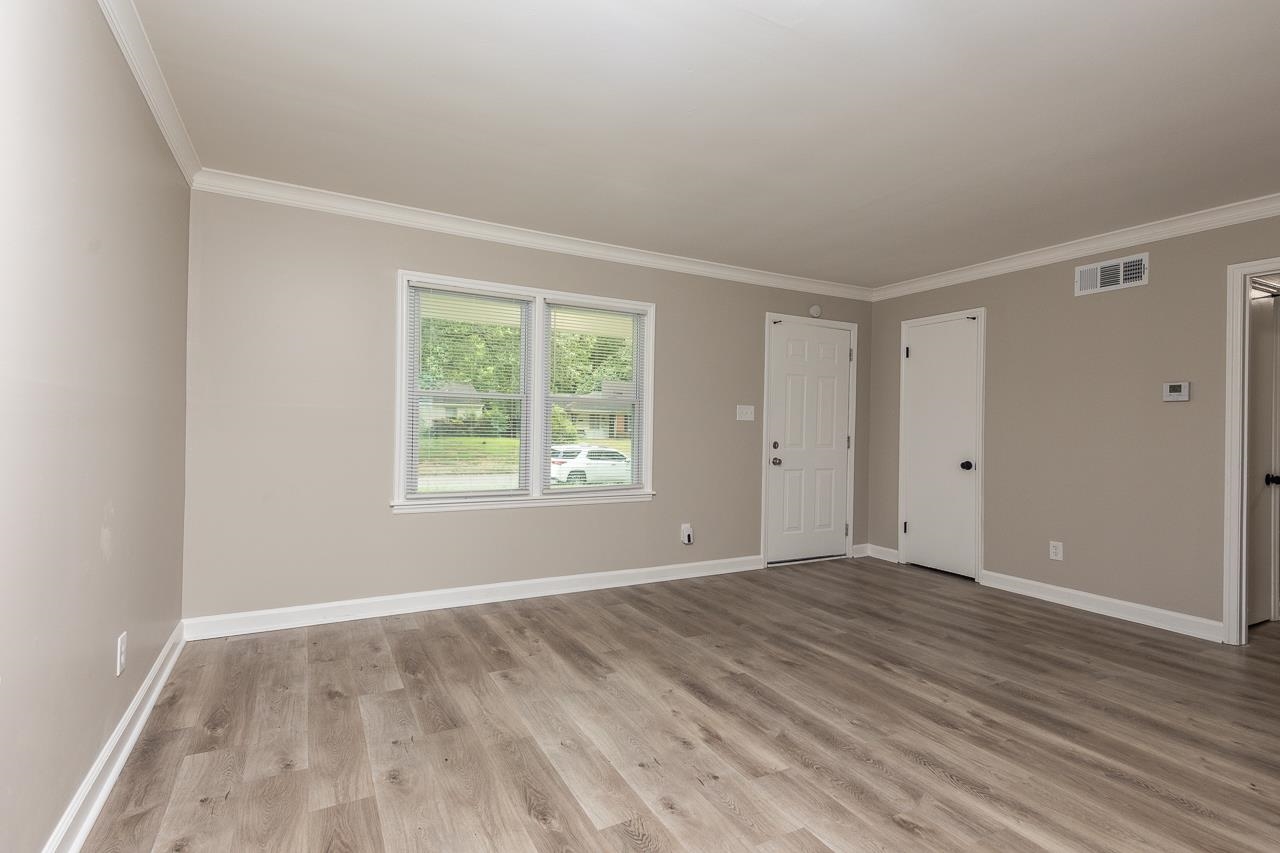 4574 Boyce Road Memphis, TN 38117 - Photo 5 of 28 a view of an empty room with wooden floor and a window