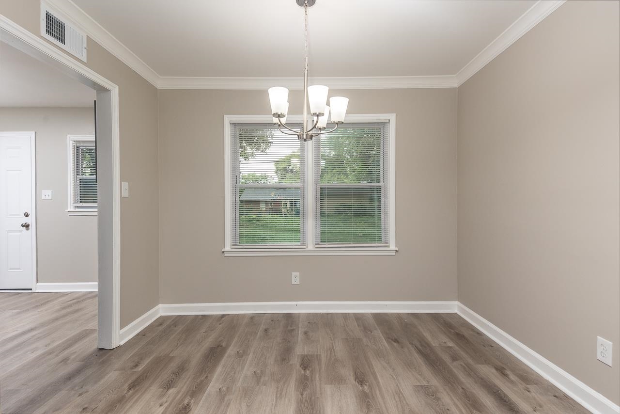 4574 Boyce Road Memphis, TN 38117 - Photo 10 of 28 an empty room with wooden floor exposed radiator and windows