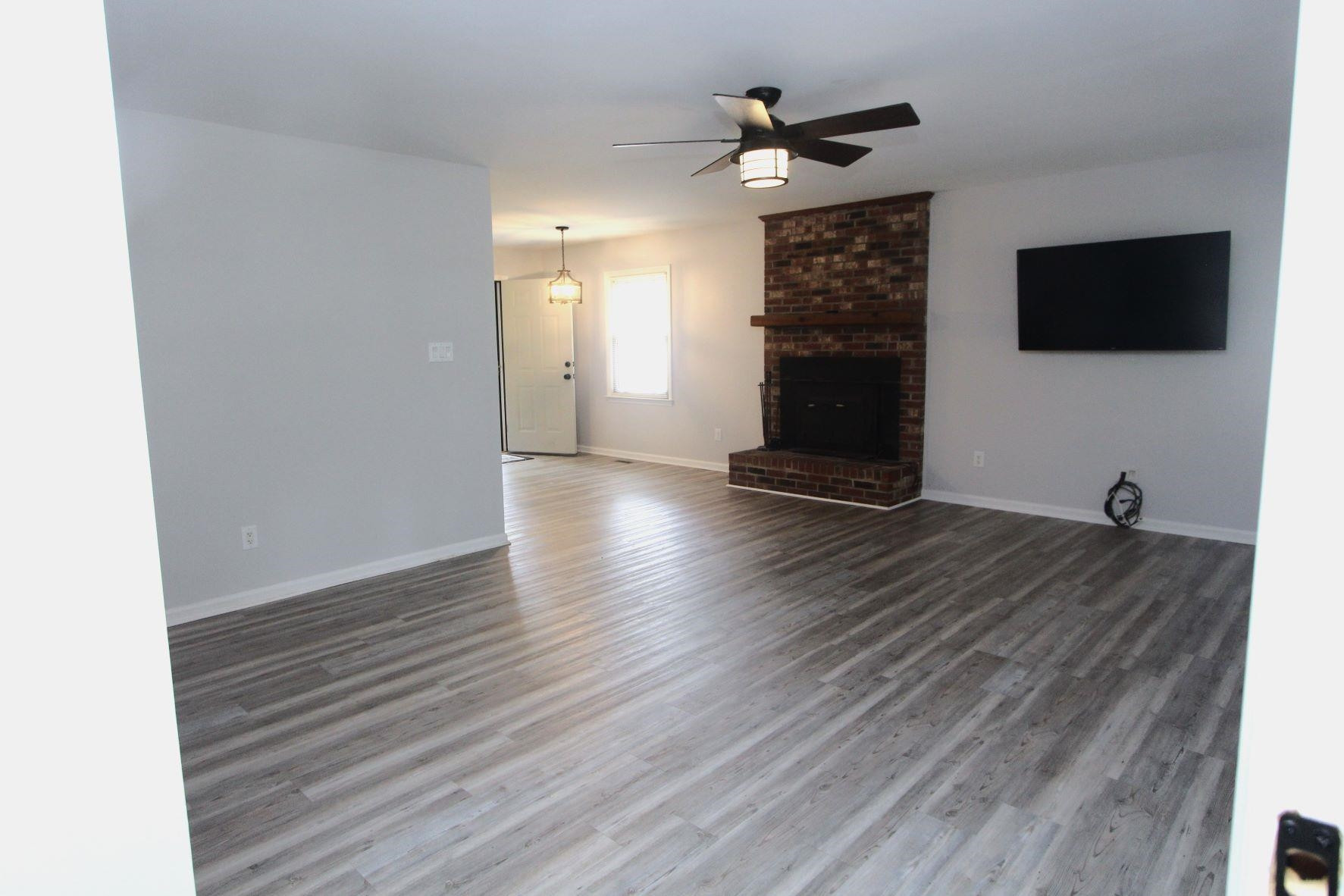 4161 Range Road Stem, NC 27581 - Photo 8 of 43 a view of a livingroom with wooden floor and a flat screen tv