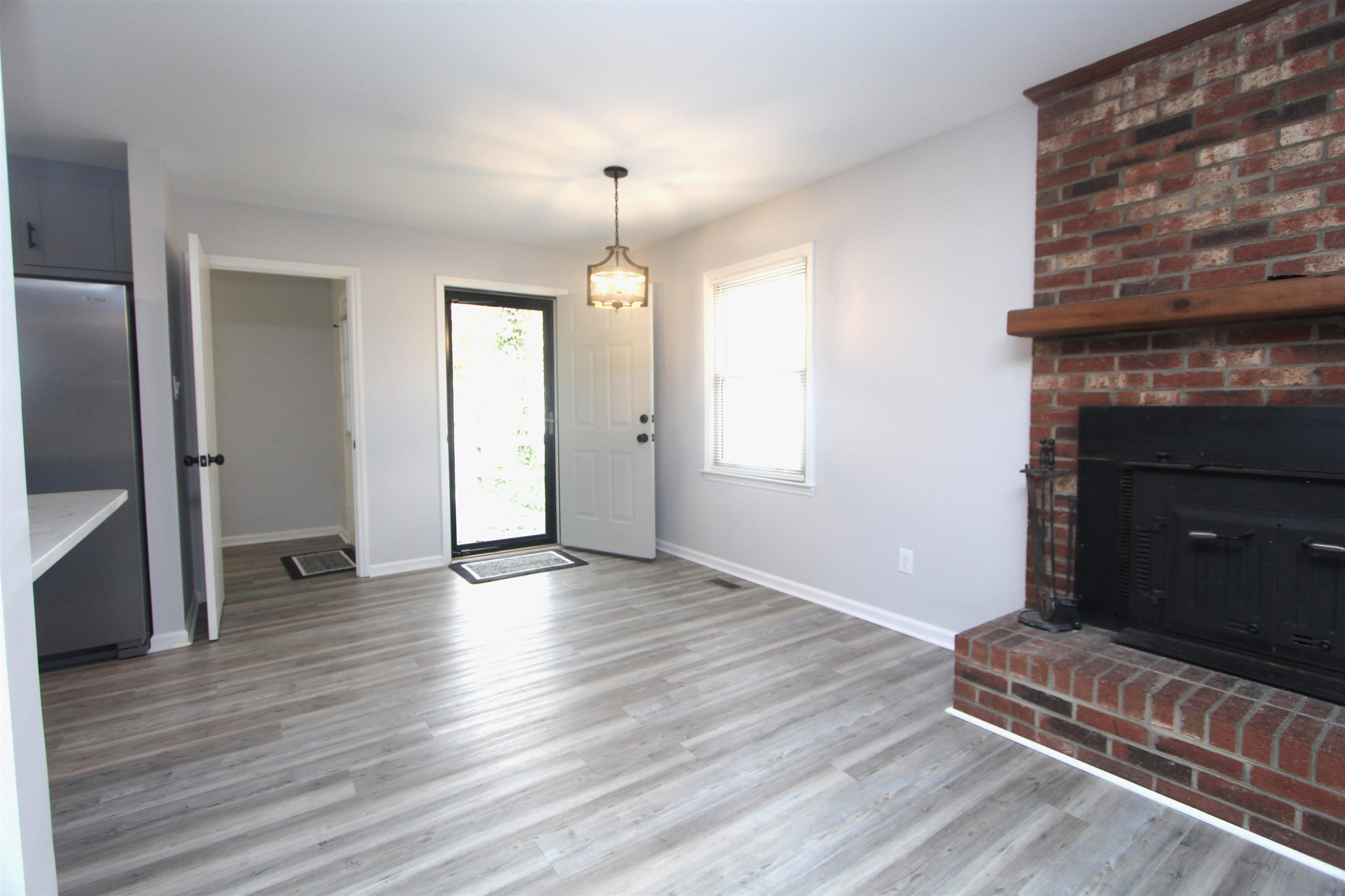 4161 Range Road Stem, NC 27581 - Photo 9 of 43 an empty room with wooden floor a fireplace and windows