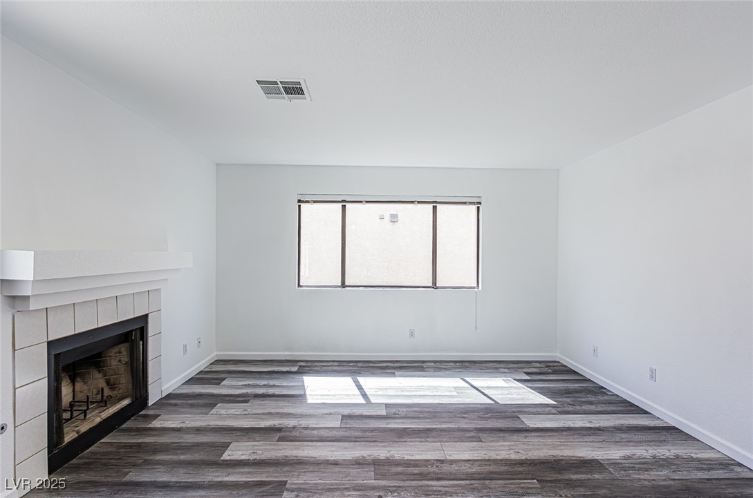 306 Lander Drive Henderson, NV 89074 - Photo 14 of 30 Unfurnished living room with dark wood-style flooring and a tiled fireplace