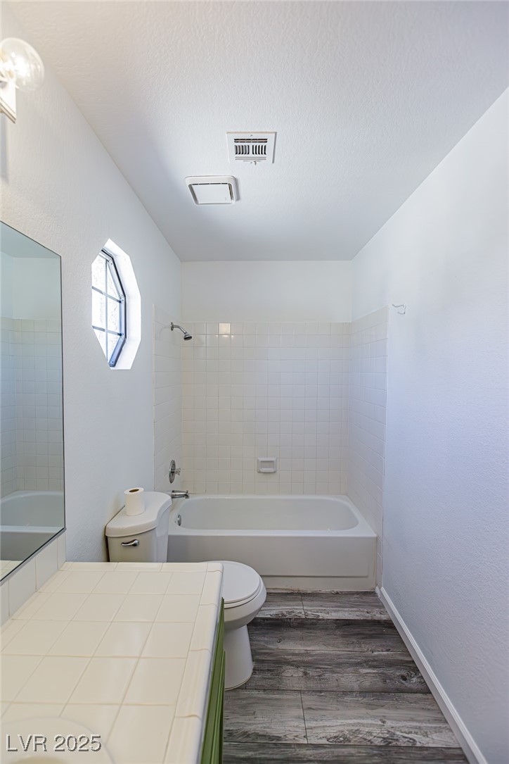 306 Lander Drive Henderson, NV 89074 - Photo 20 of 30 Bathroom featuring shower / bathtub combination, dark wood-type flooring, vanity, and a textured ceiling