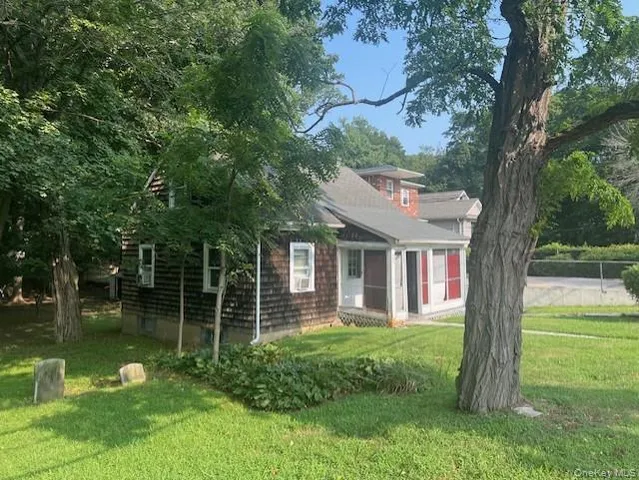 a view of a house with backyard and a tree