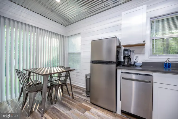 a kitchen with a table chairs refrigerator and window