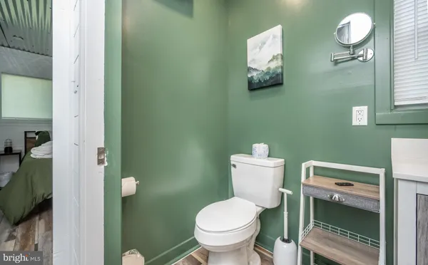 a white toilet sitting next to a bathroom sink and vanity
