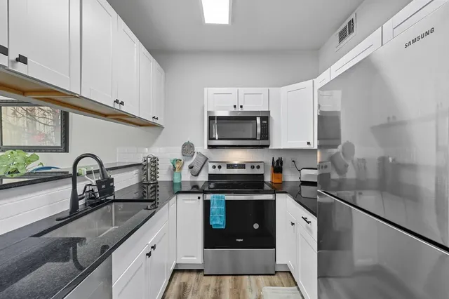 a kitchen with a sink a stove and cabinets