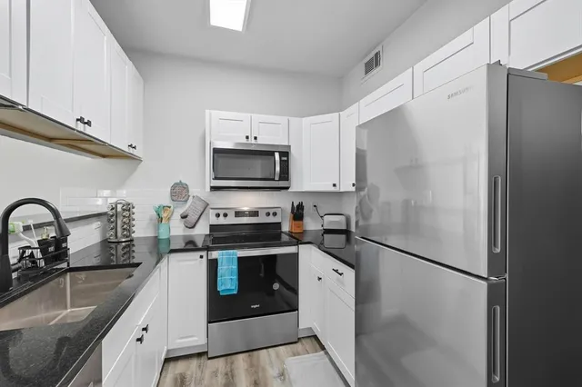 a kitchen with stainless steel appliances a refrigerator sink and microwave