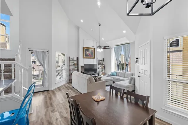 a living room with furniture a chandelier and a dining table