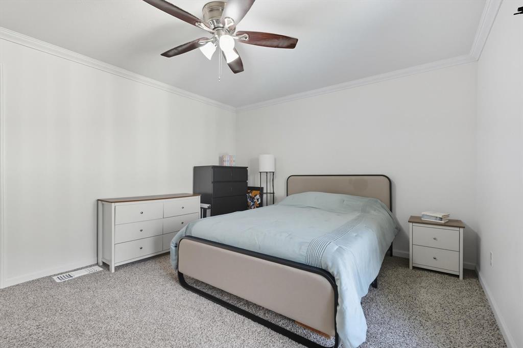 4430 Point Boulevard, Unit 203 Garland, TX 75043 - Photo 24 of 40 a room with a bed and a ceiling fan