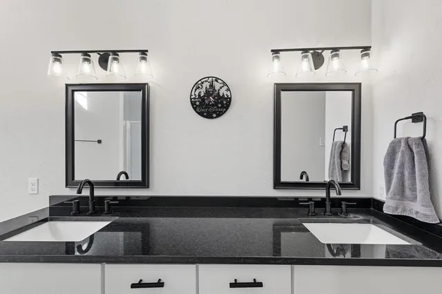 a spacious bathroom with a double vanity sink and a mirror