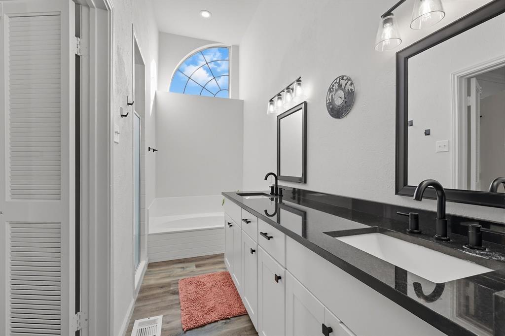 4430 Point Boulevard, Unit 203 Garland, TX 75043 - Photo 29 of 40 a spacious bathroom with a double vanity sink and a mirror